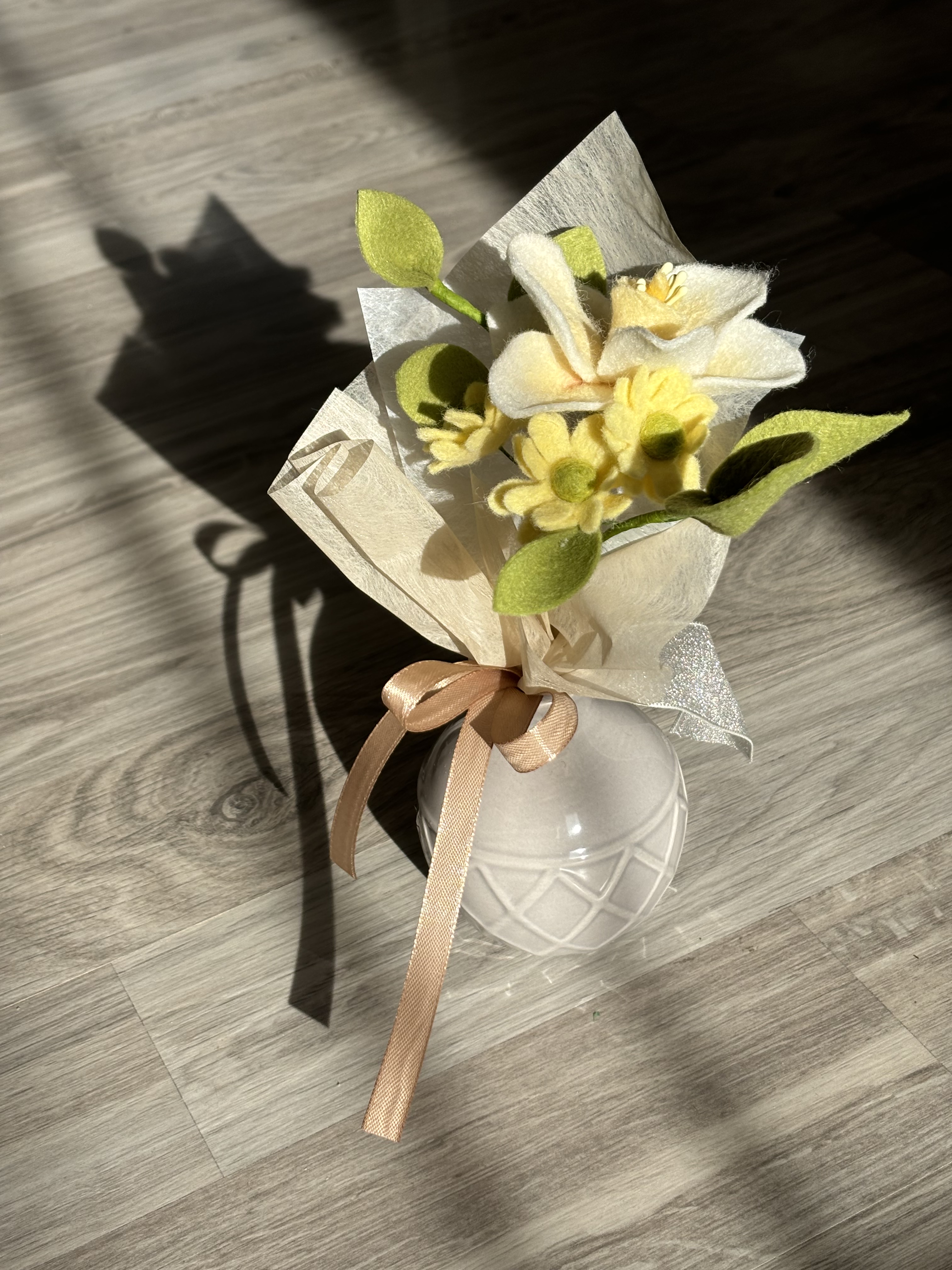 Decemberi születésvirág, nárcisz csokorba kötve sárga kisvirágokkaé és némi levéllel, díszes masnival.